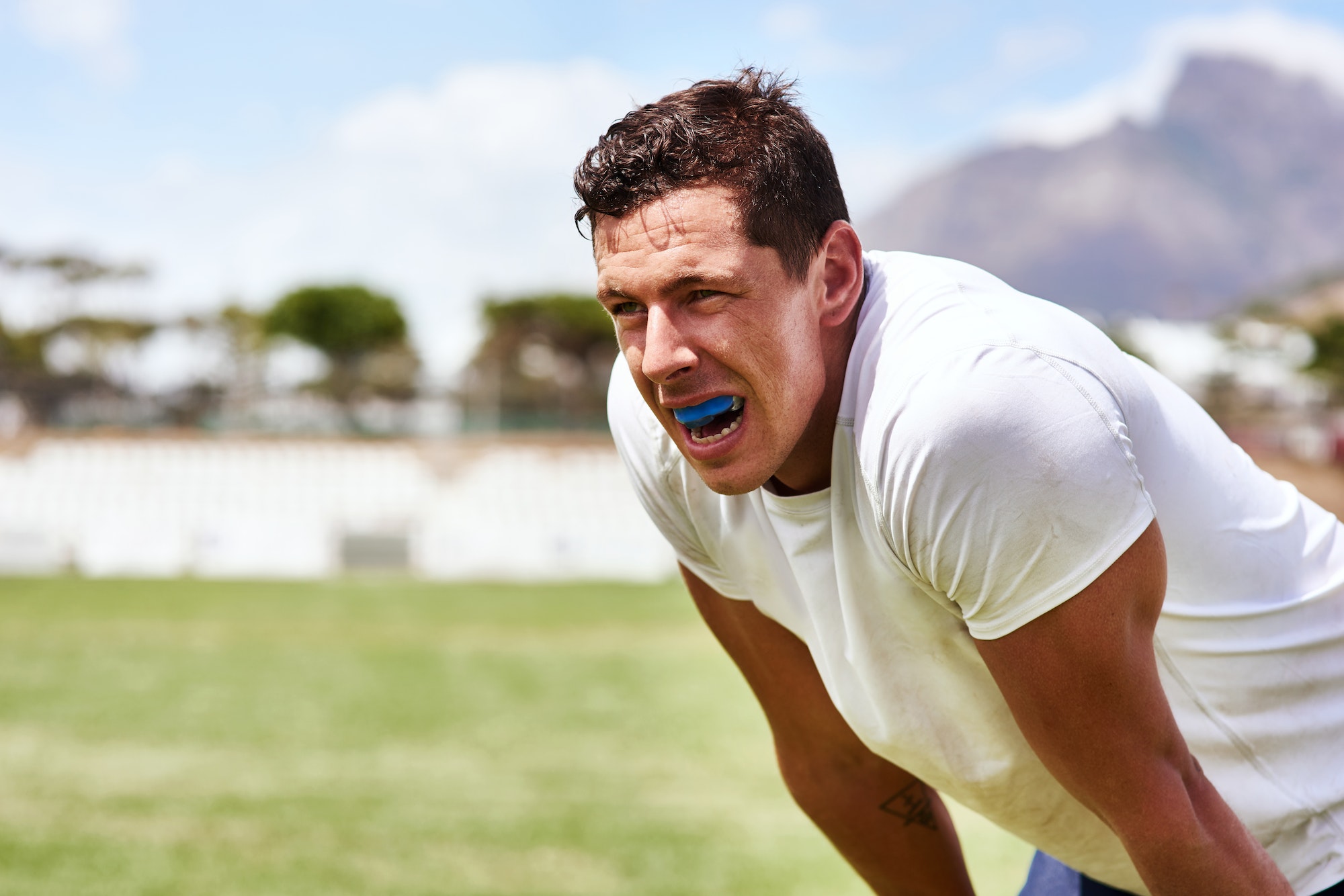 Shot of a young man wearing a gum guard while playing a game of rugby